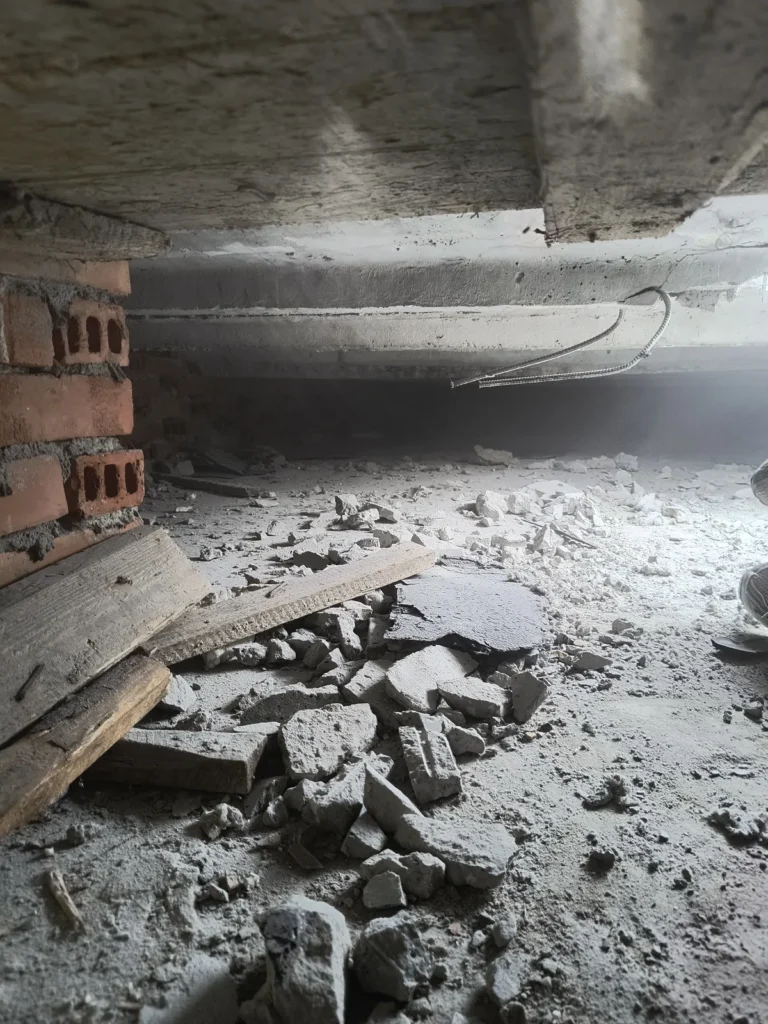 Usunięte fragmenty zawilgoconej wełny i gruz.